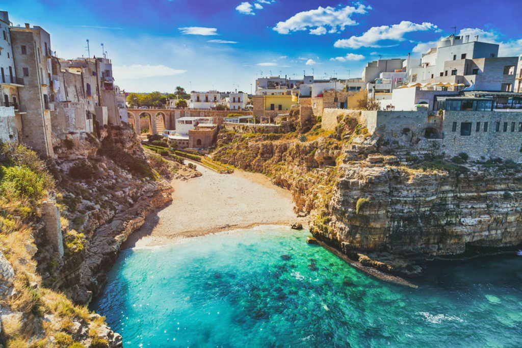 beach surrounded by cliffs in poligano